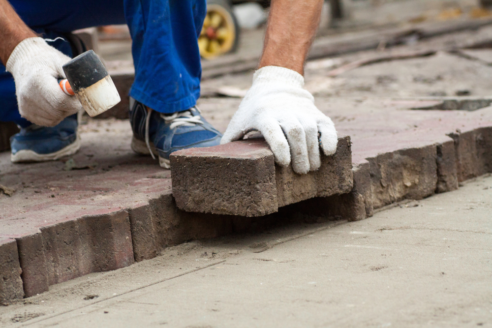 paver installing masonry paving stones.
